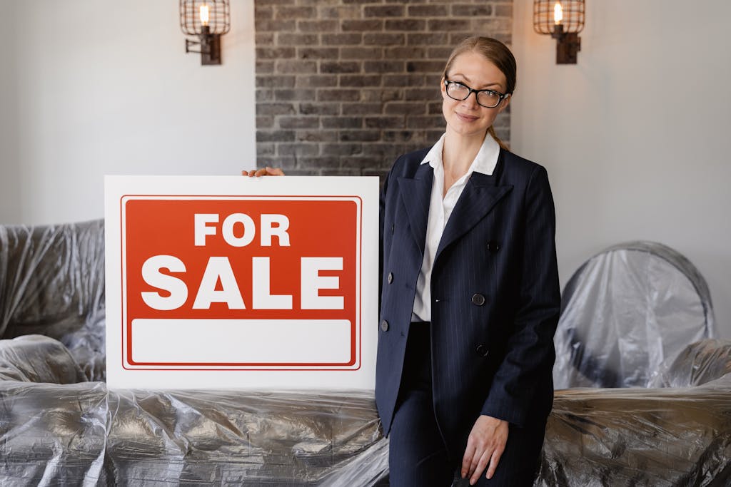 Mortgage Broker or Realtor: Which One Should You Go For? 2 A Woman in Formal Blazer Holding a Signage while Leaning on a Covered Sofa